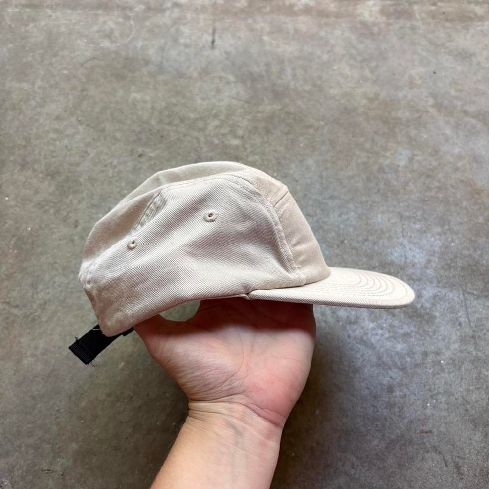 Tan five panel baseball cap with black strap